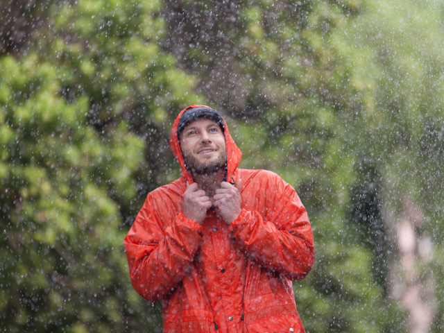 滝のしぶきにあたる男性